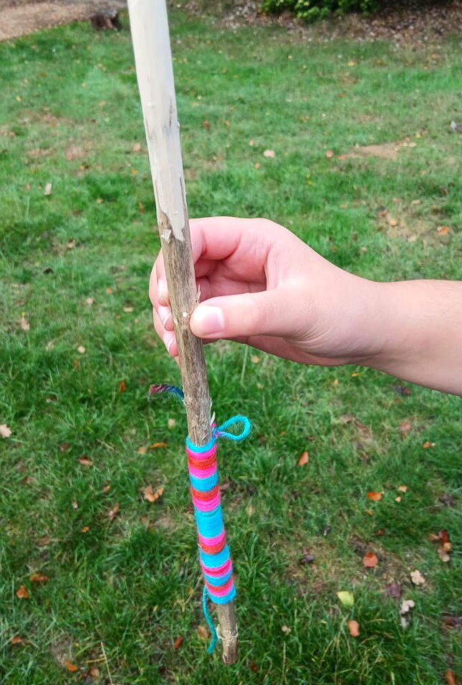 A whittled tool with a rainbow-wrapped handle, proudly displayed